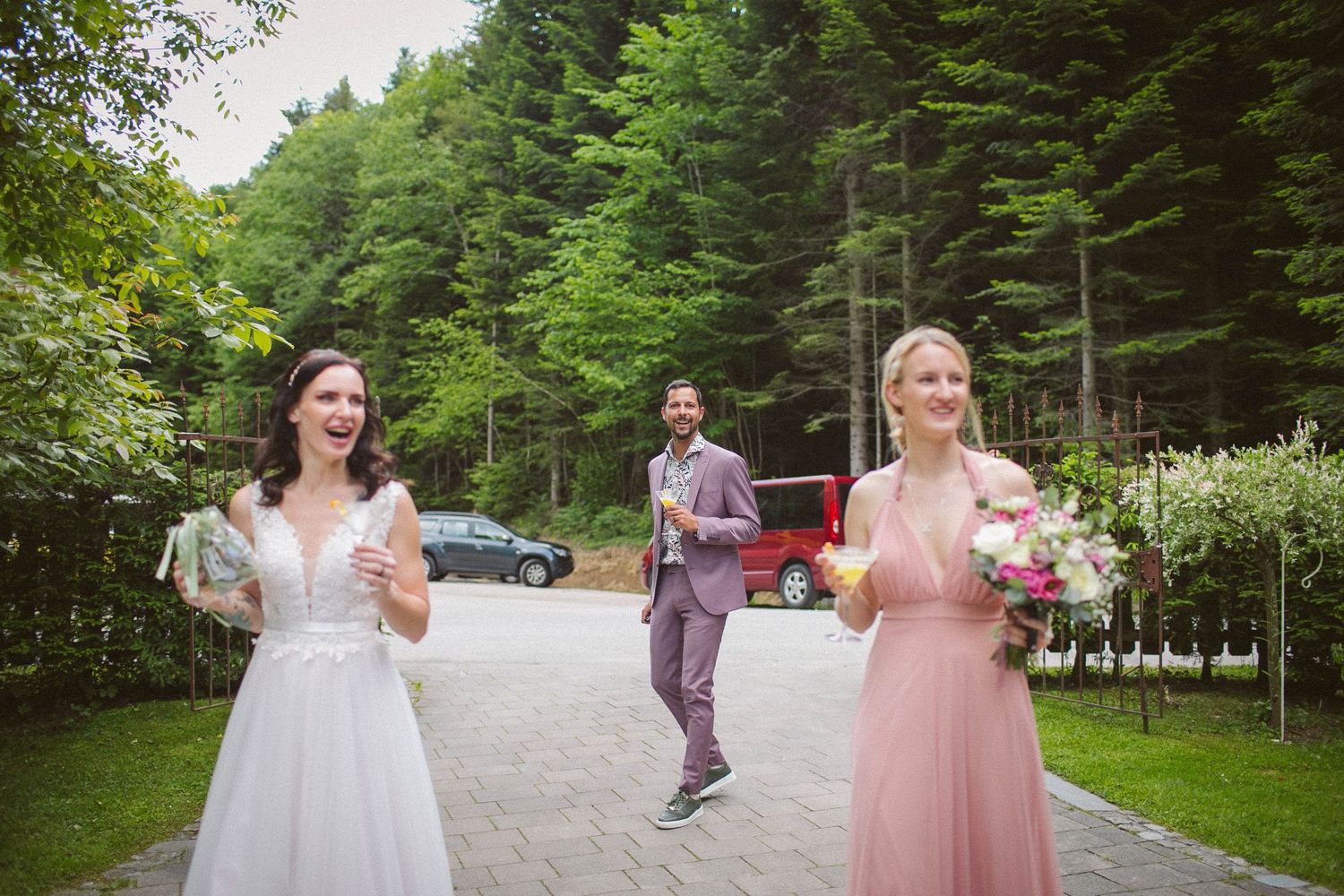 People celebrating on a forest path with evergreen trees in the background.