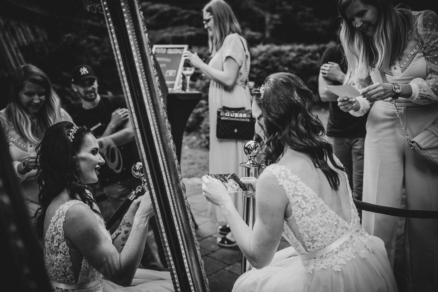 Black and white photo of guests gathered around at an outdoor celebration.