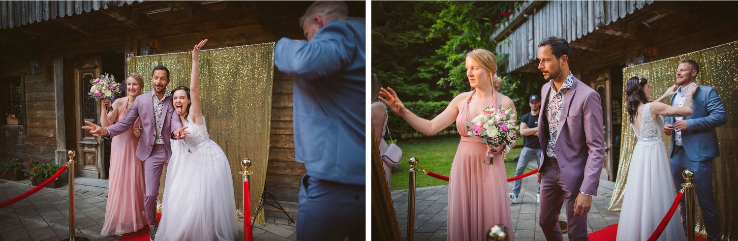 Wedding party celebrates outside rustic venue with gold backdrop and pink bridesmaids dresses.