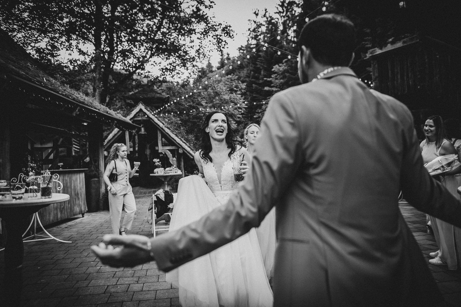 A black and white photo capturing a joyful moment during an outdoor celebration.
