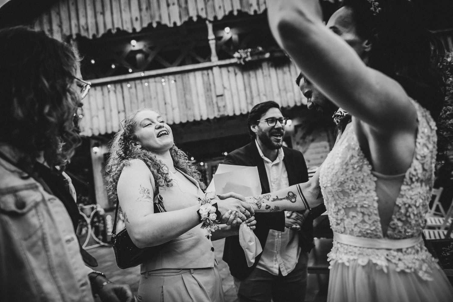 A black and white photo showing people dancing and laughing at an outdoor celebration.