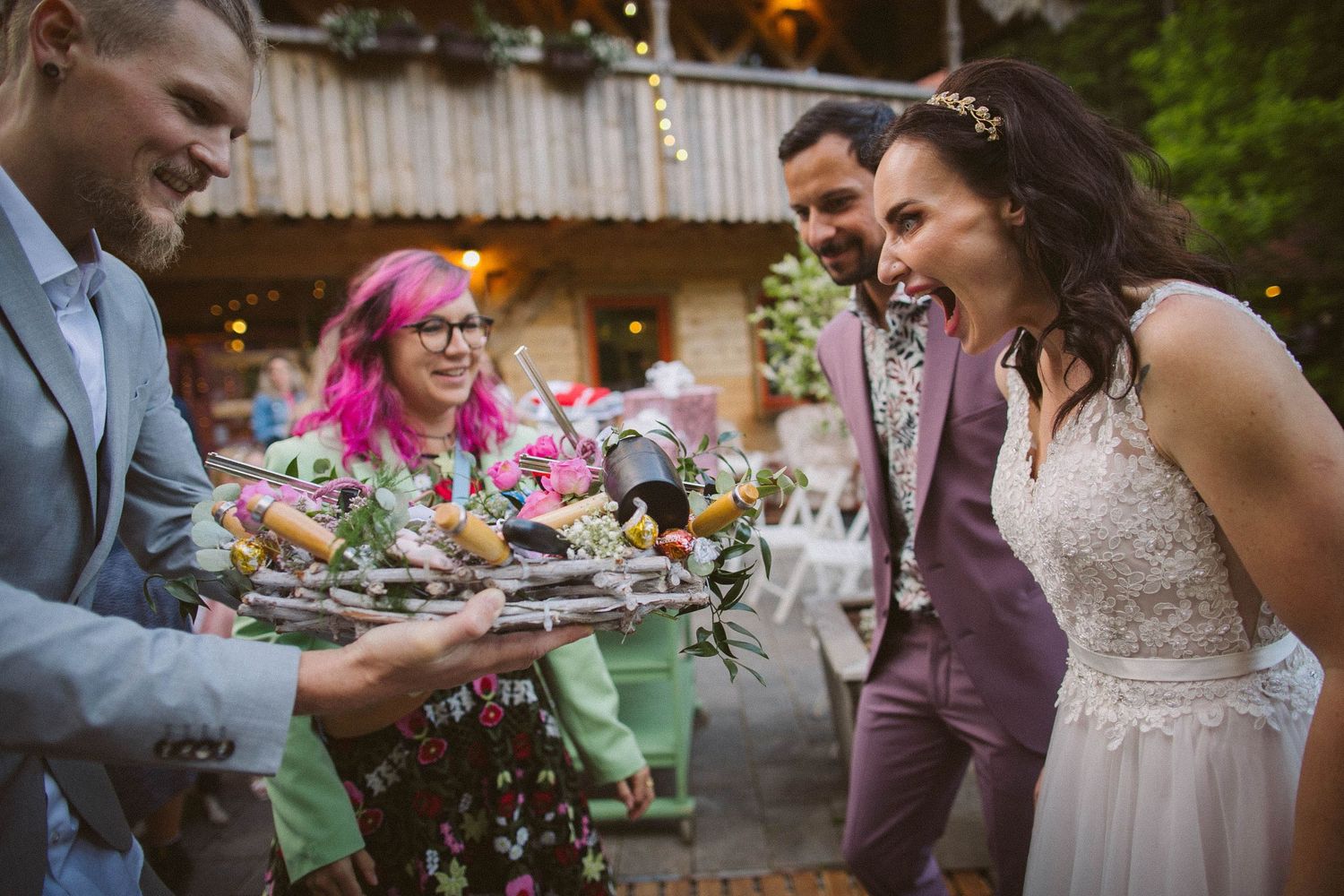 Celebratory moment at an outdoor reception with confetti and string lights overhead.