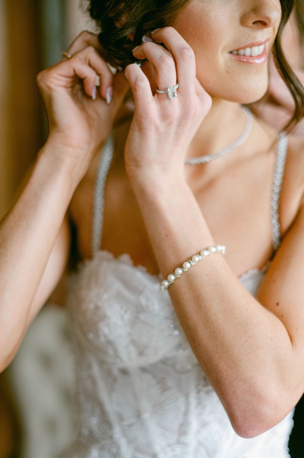 Detailed view of a white lace wedding dress bodice with delicate beaded straps.