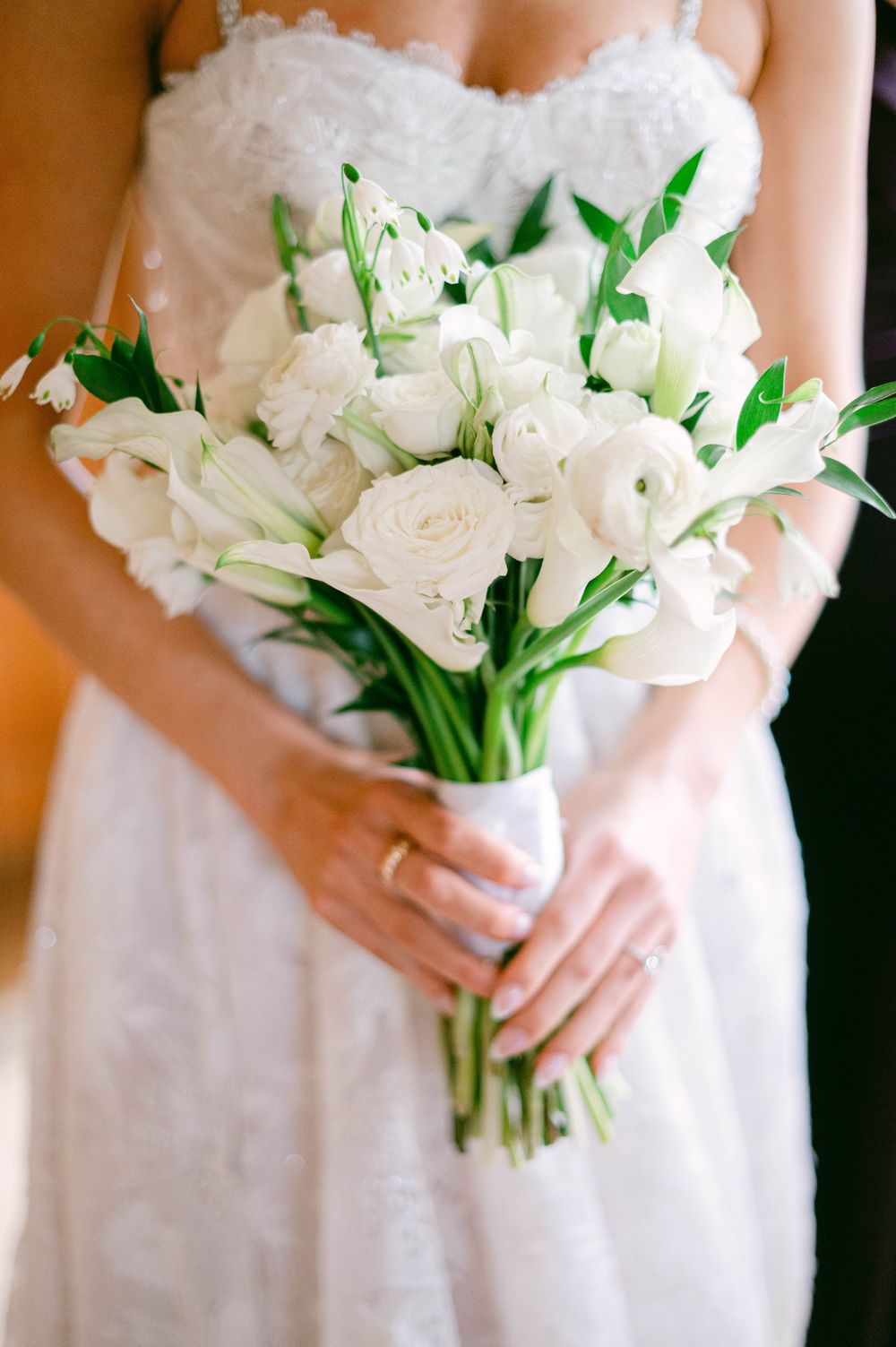 Natural sunlight illuminates a timeless bridal portrait with white roses and wood paneled room.