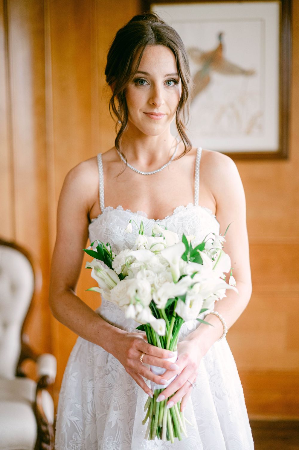 Classic wedding scene with ivy-covered walls and white floral arrangements on pedestals.