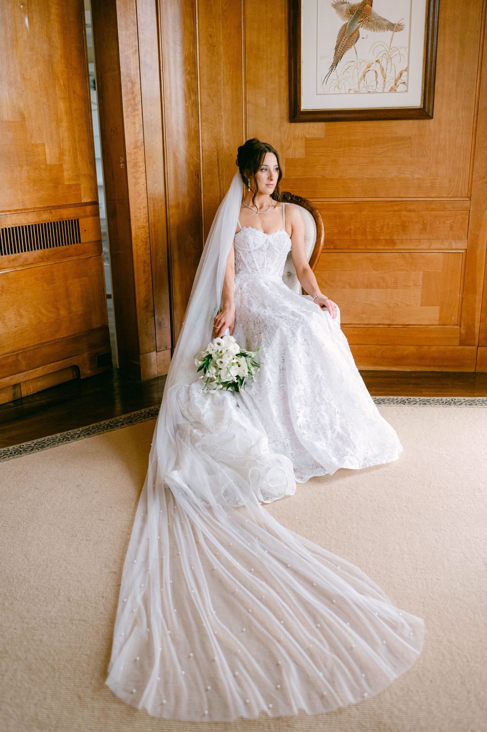 A flowing white wedding gown twirls in an elegant wood-paneled room.