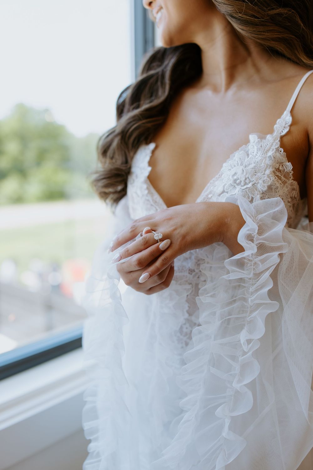 Close-up details of a white ruffled wedding dress bodice with delicate lace trim.