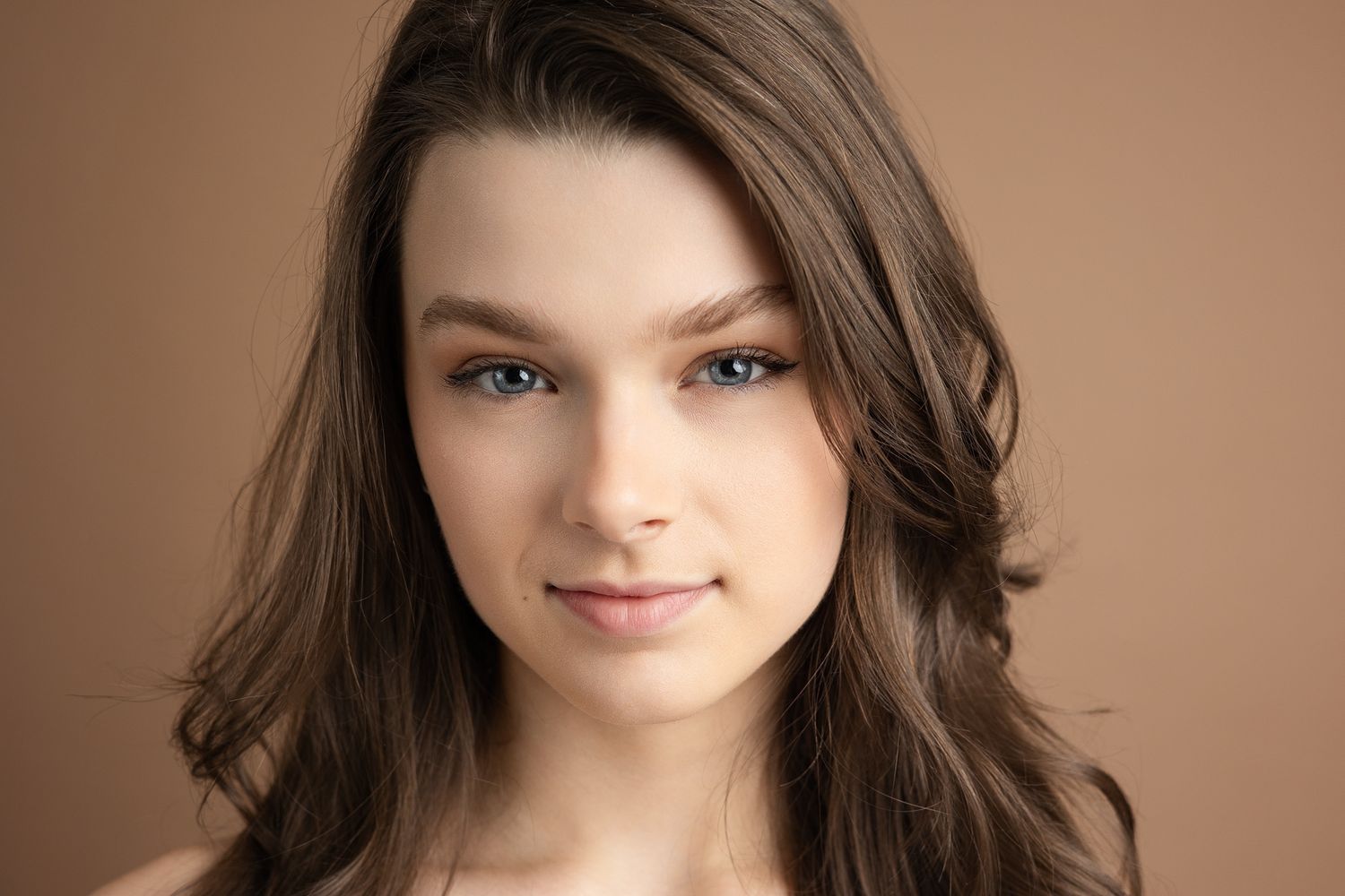 Model and actor top headshots in London Ontario, agency represented model with brown hair and mocha background