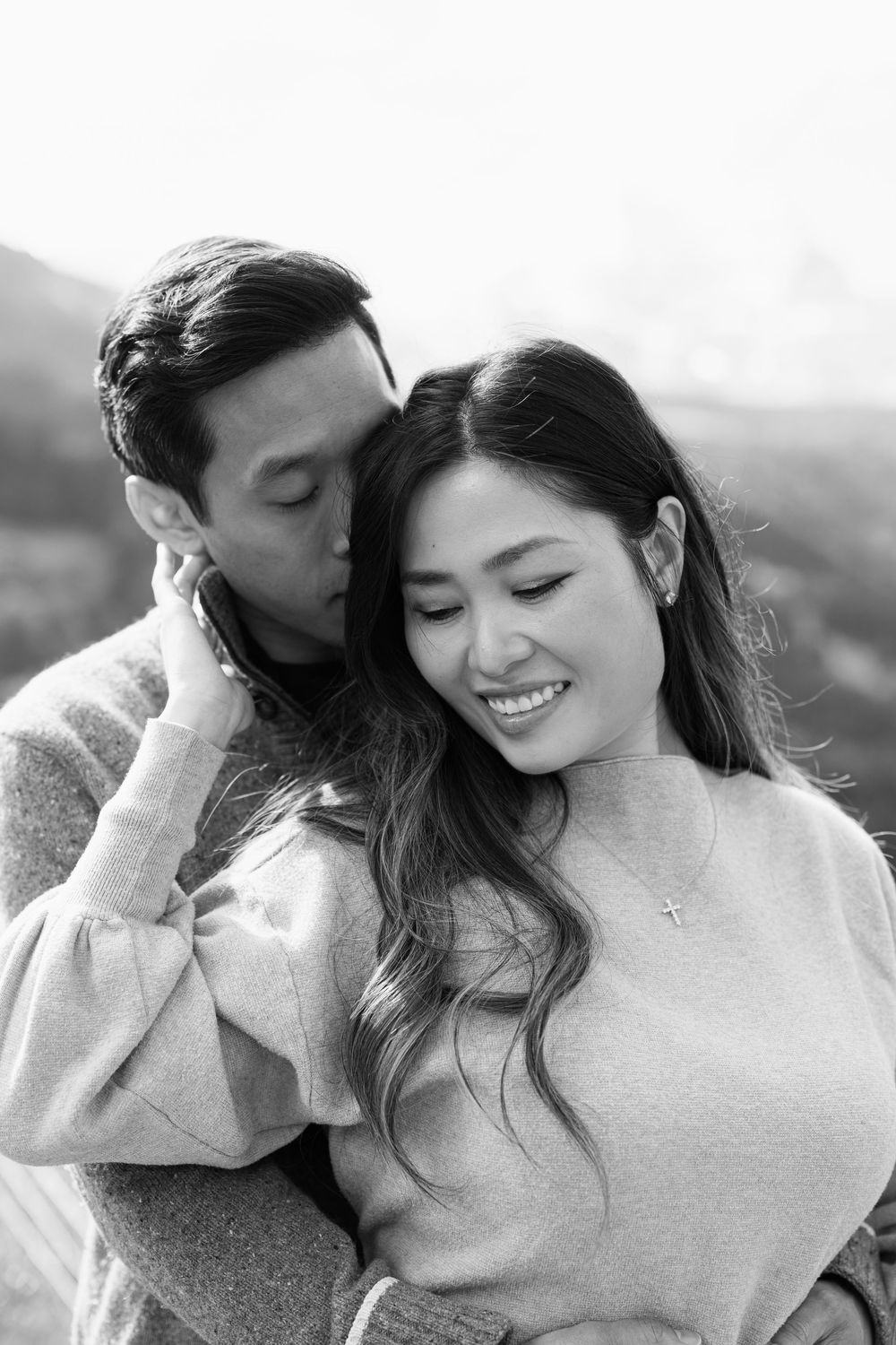 A romantic black and white photo series showing tender moments between a couple in cozy sweaters.