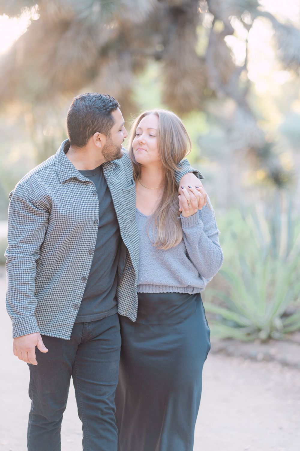 Romantic couple shares tender moments in a series of outdoor engagement photos with soft natural lighting.