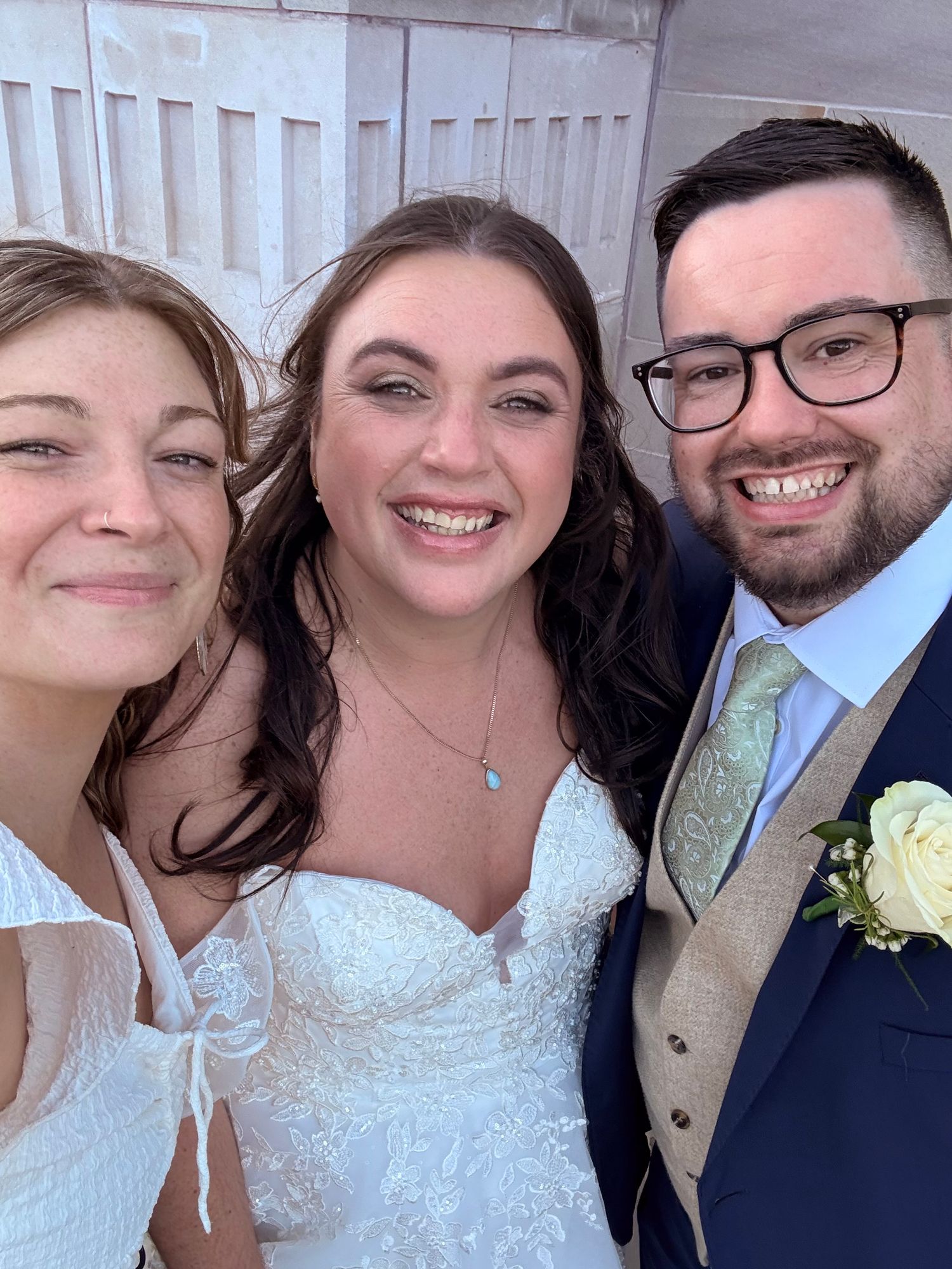 Selfie photo of the bride and groom and content creator, smiling.