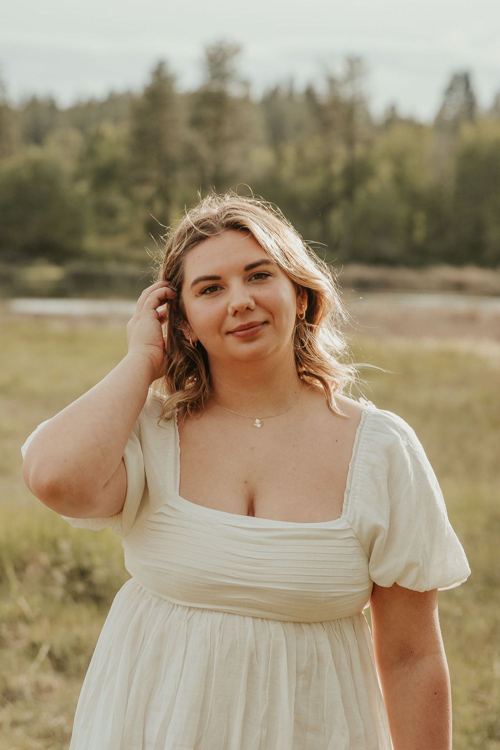 Outdoor senior portraits for high school graduate in Eastern Washington wearing a white dress in an open country field