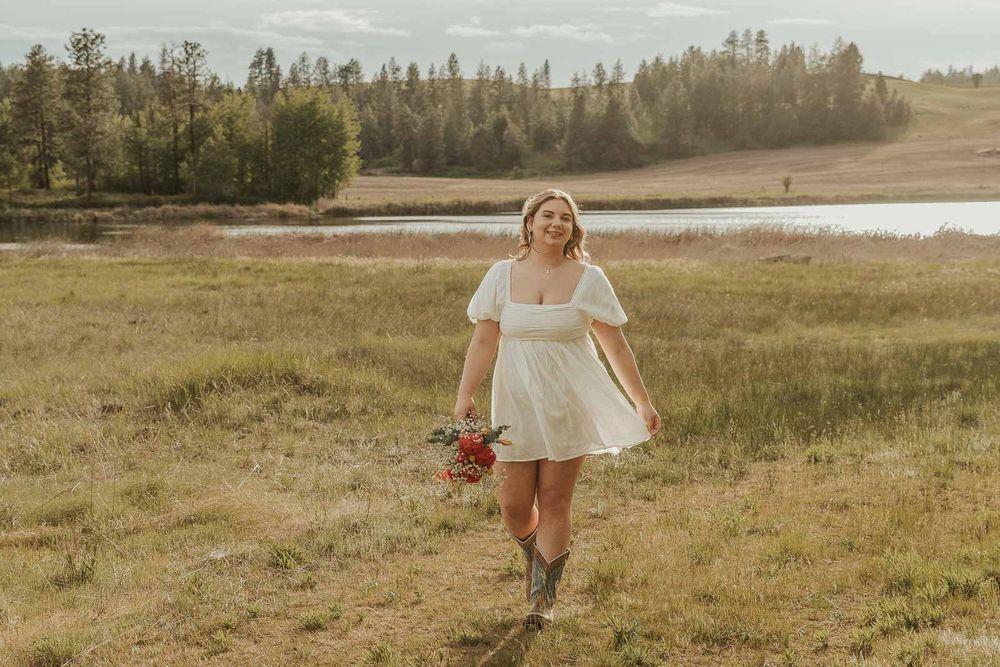 Davenport High School senior girl in white puff sleeve dress and turquoise cowgirl boots at golden hour outdoor photo session in Spokane wa