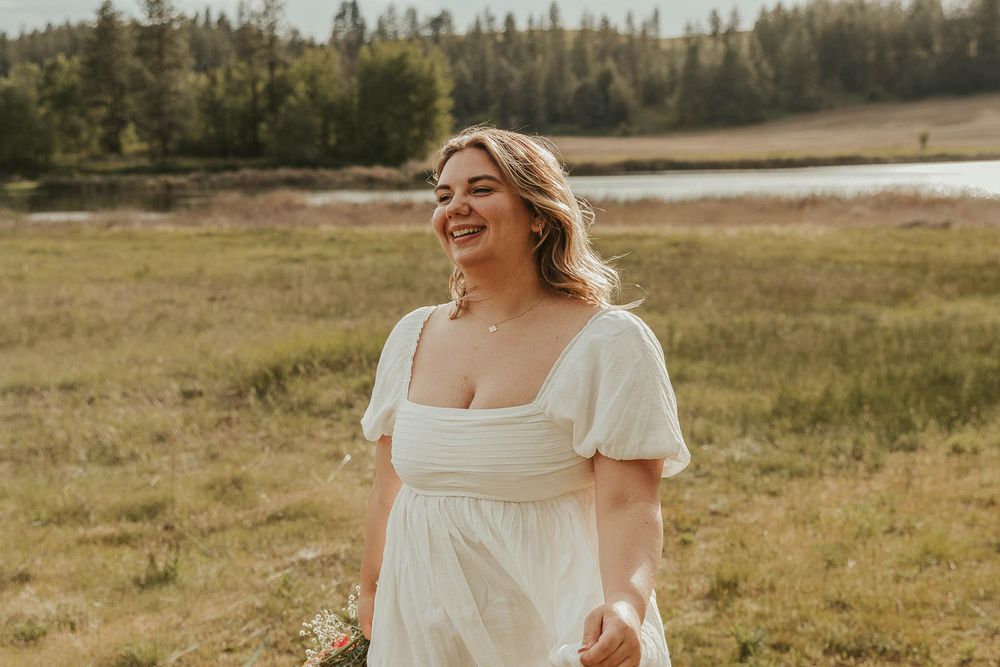 Close-up of smiling Class of 2025 senior from Davenport High School during golden hour senior session in field near Spokane at rustic venue