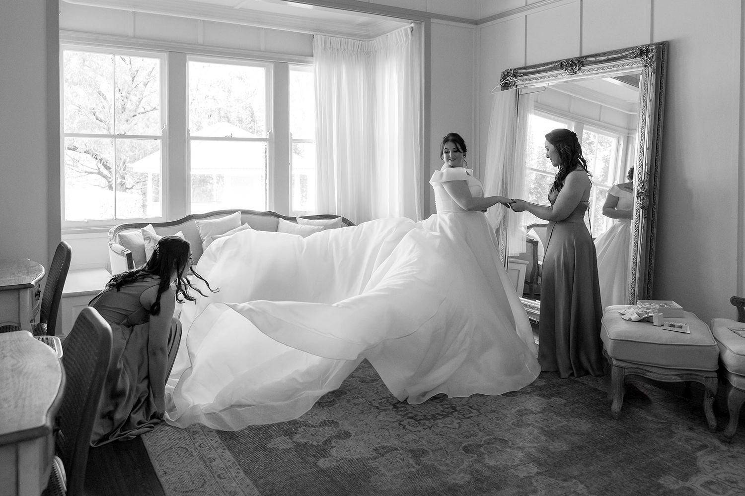 A black and white photo of a Brides wedding dress preparations in a bright room with a large window at Gabbinbar Homestead in Toowoomba.