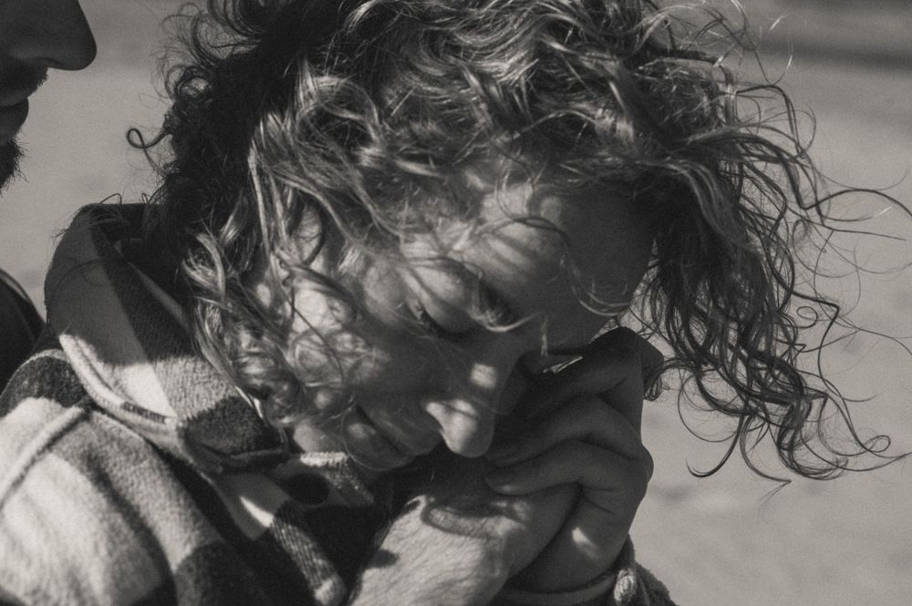 Black and white portrait of curly hair blowing in the coastal wind.