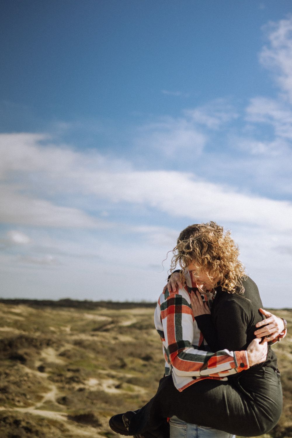 Emotional outdoor portrait session in a windswept coastal landscape.