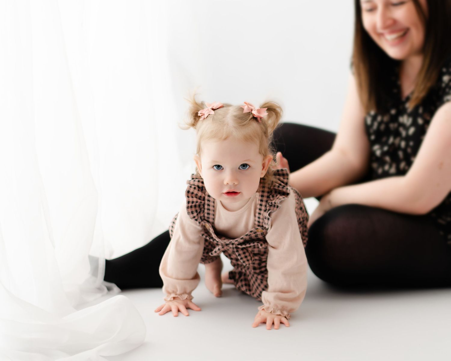6 month old baby lying on back looking at camera with a cheeky smile.