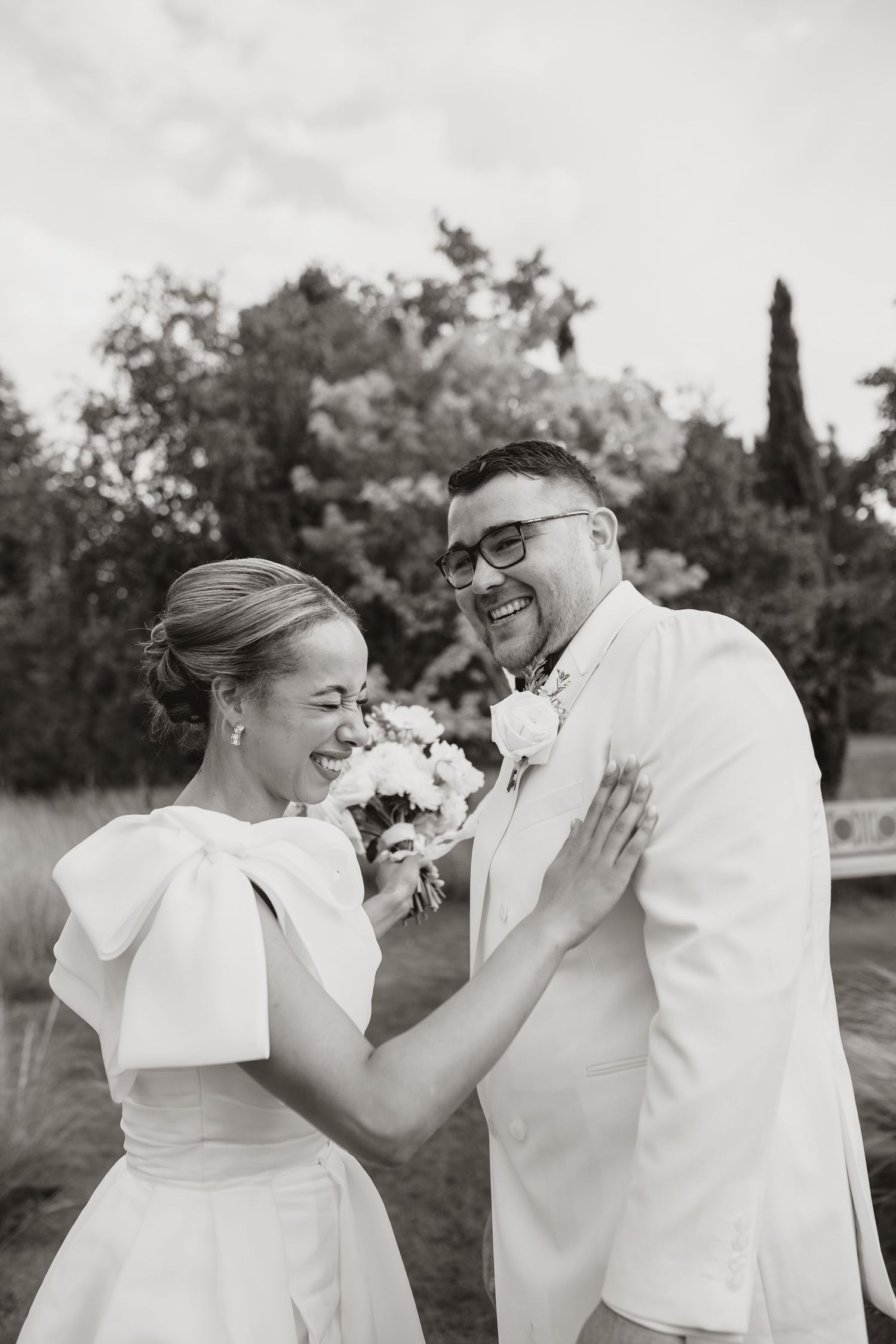 Black and white capture of joyful celebration with champagne spray in an outdoor setting.