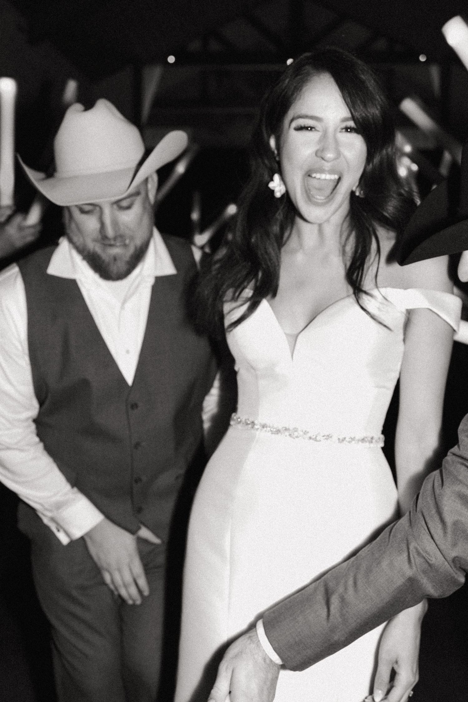 Black and white wedding reception photo capturing joyful dancing moment.