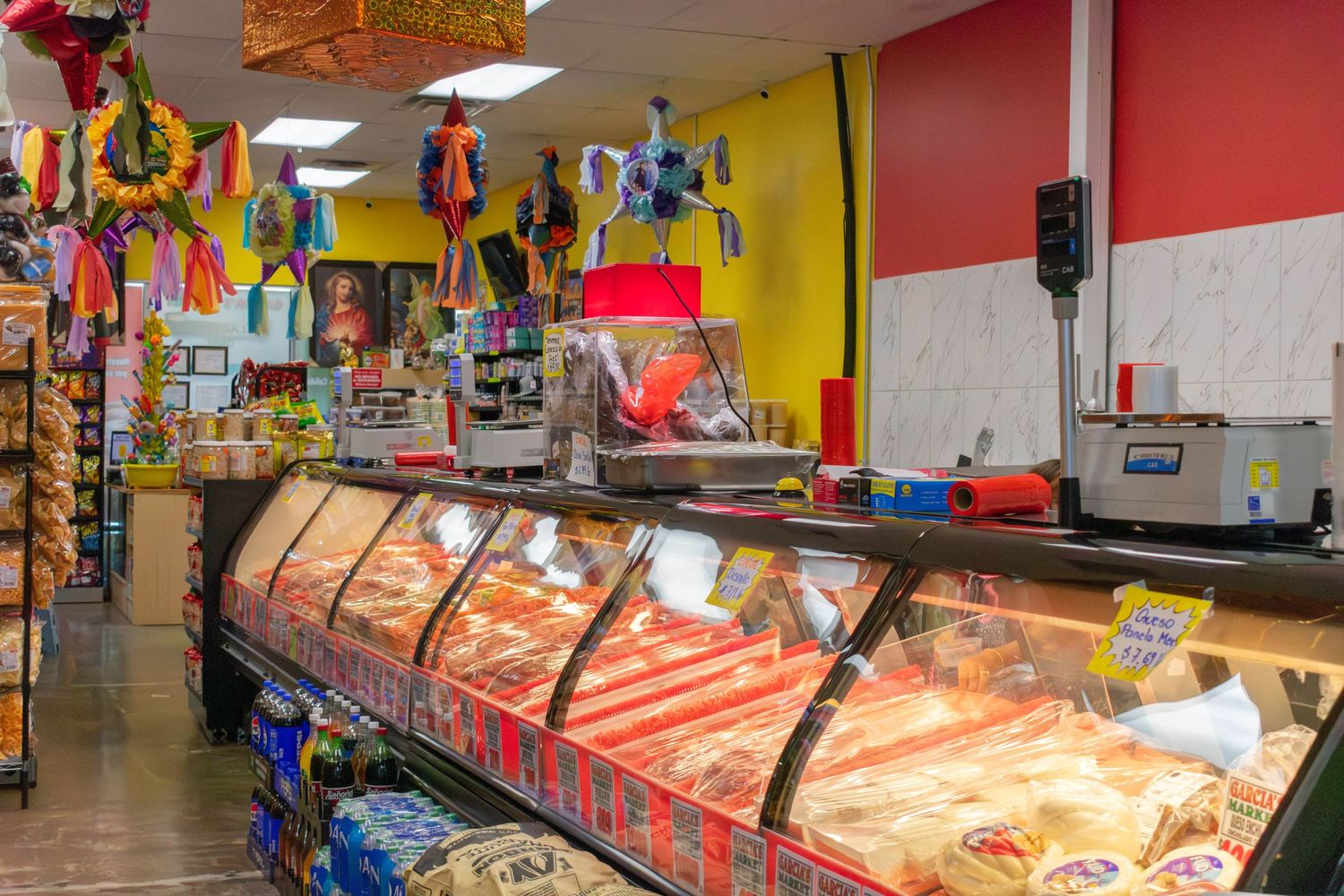 Interior of a grocery store meat department with colorful decorations and well-stocked display cases.