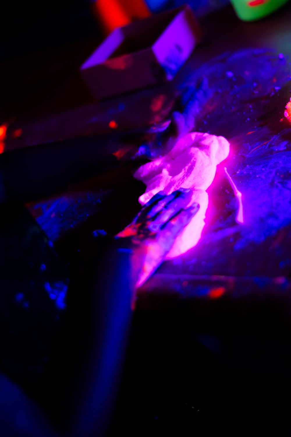 Abstract neon lights creating colorful patterns in pink, blue and red against black background.