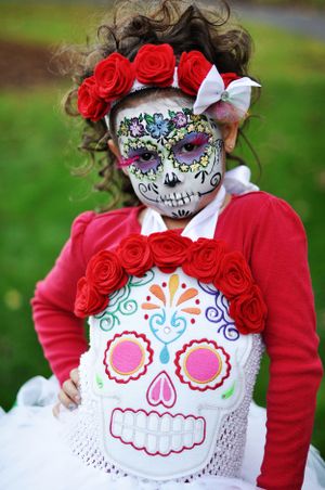 Day of the Dead sugar skull costume with red roses and butterfly accessories.