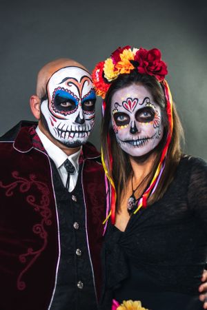 Couple wearing traditional Day of the Dead sugar skull makeup and formal attire.