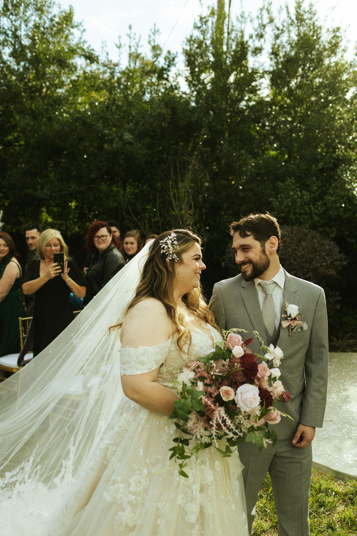 A bride and groom smiling at each other as they leave their ceremony walking down the aisle