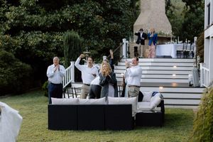 Wedding guests enjoying refreshments on outdoor seating area with white steps and landscaping.