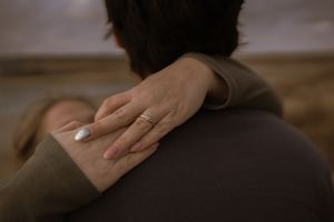 Gentle hands touching in soft focus black and white photography.