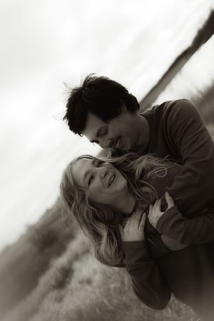 An intimate black and white portrait of two people in a loving embrace.