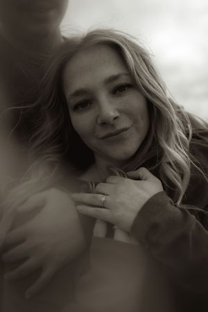 A close-up portrait shows a woman with wavy blonde hair smiling softly in natural light.