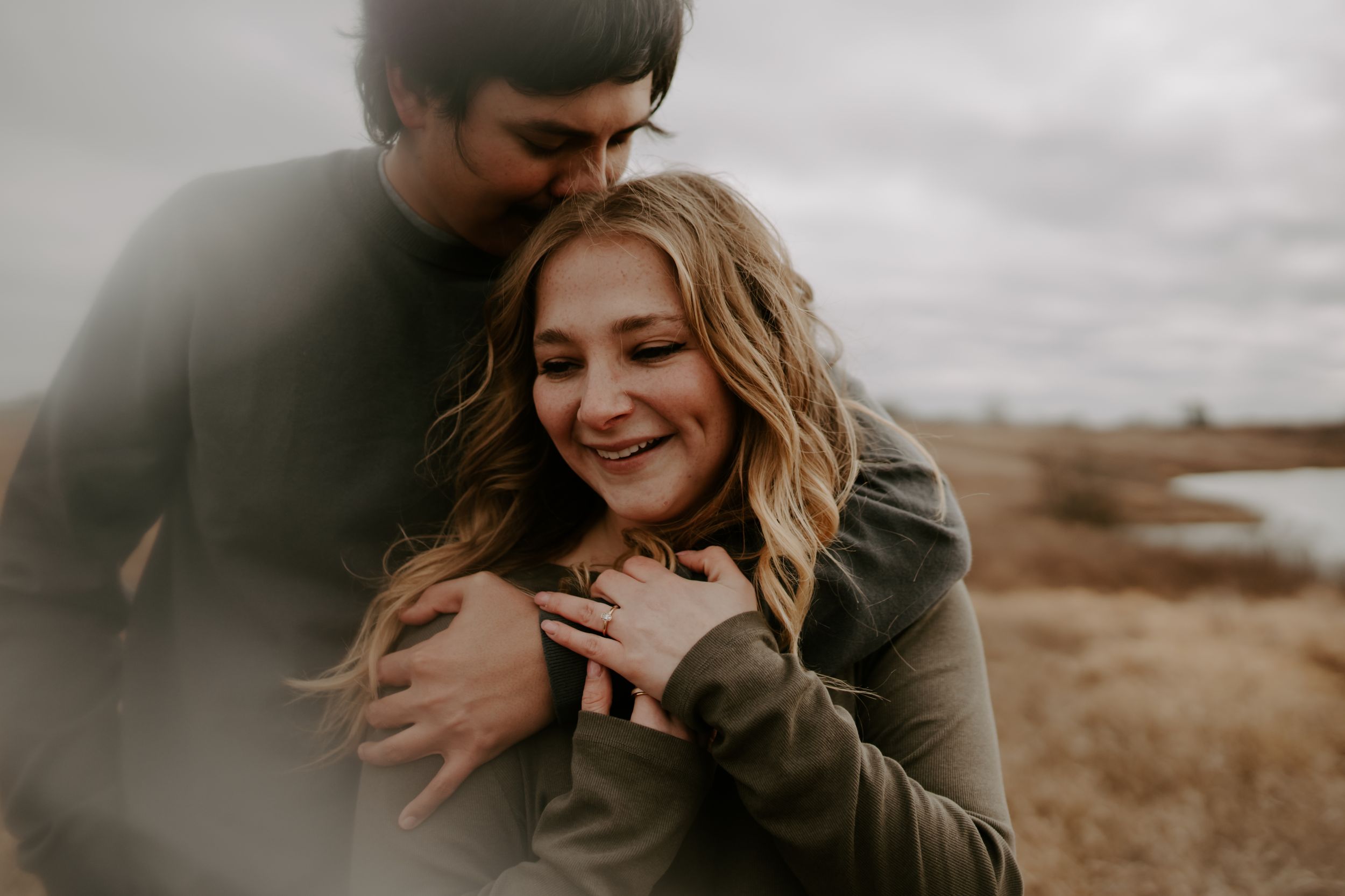 Romantic candid moments captured in moody outdoor setting.