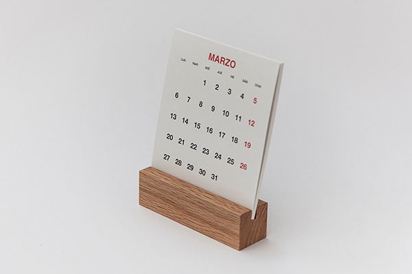 Close-up view of a wall calendar showing numbered dates in black and red against a white background.