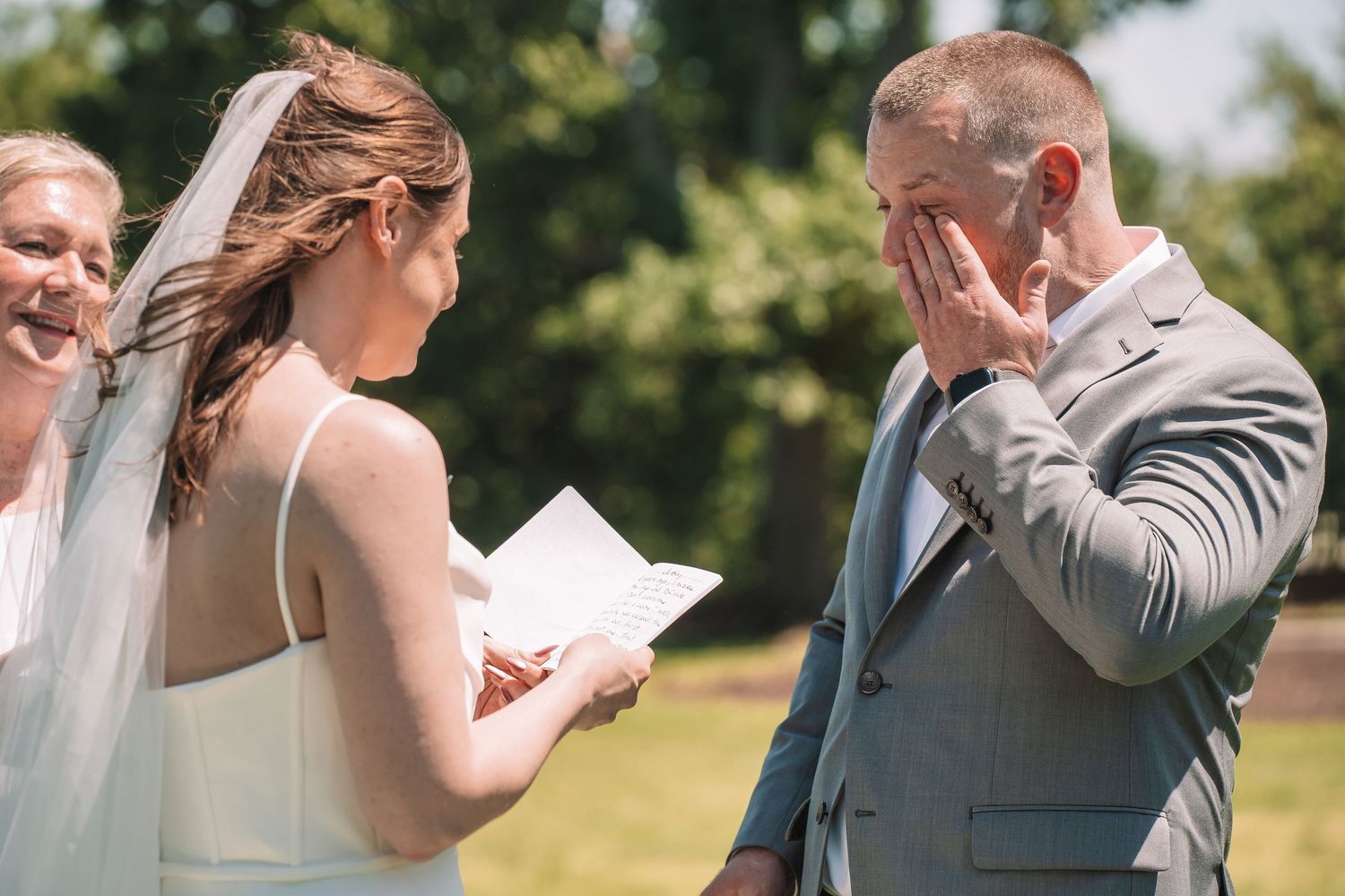 Wedding couples share emotional first looks during outdoor garden photo sessions in sunlit summer weather.
