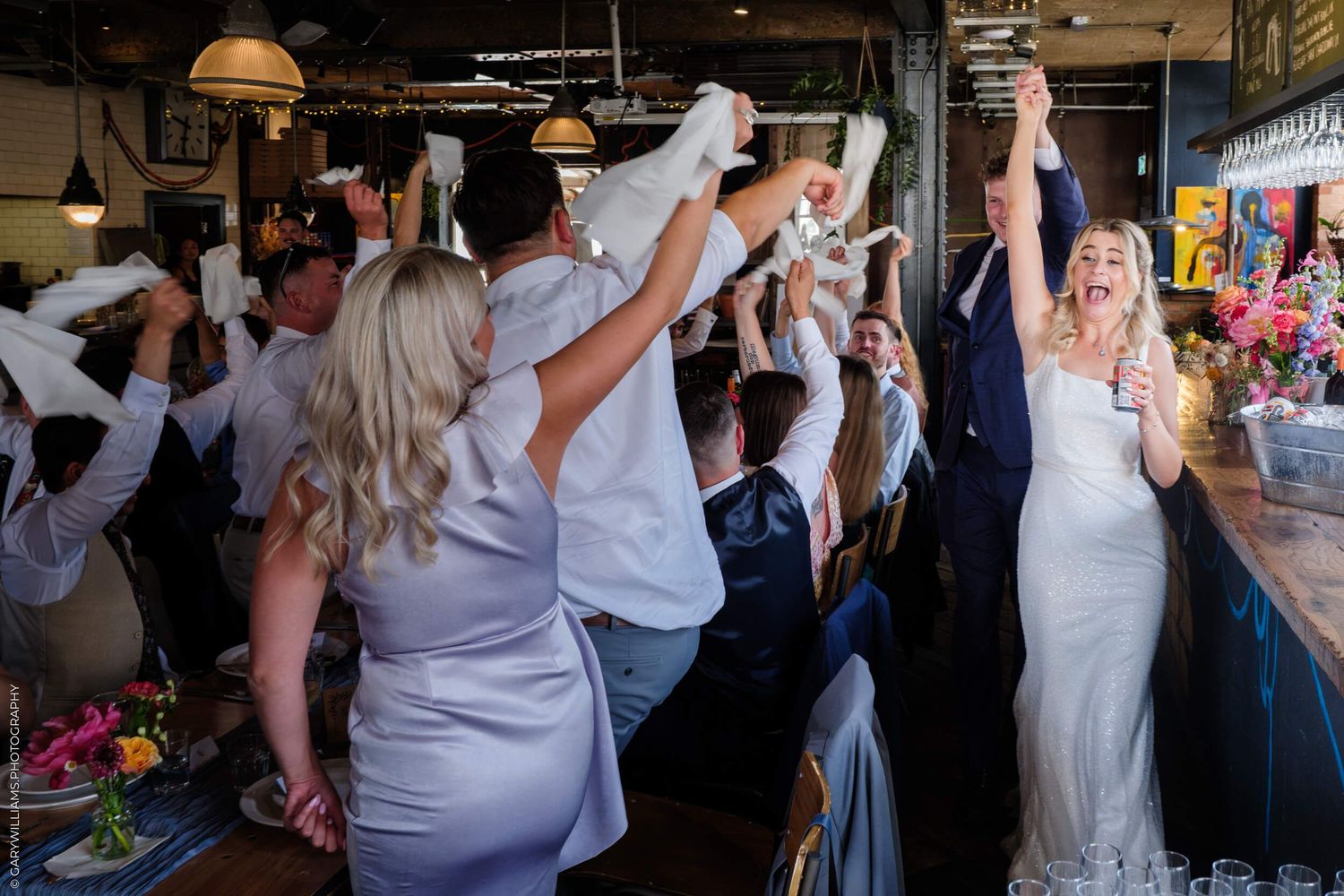 Wedding reception guests dancing and celebrating together on a crowded dance floor.