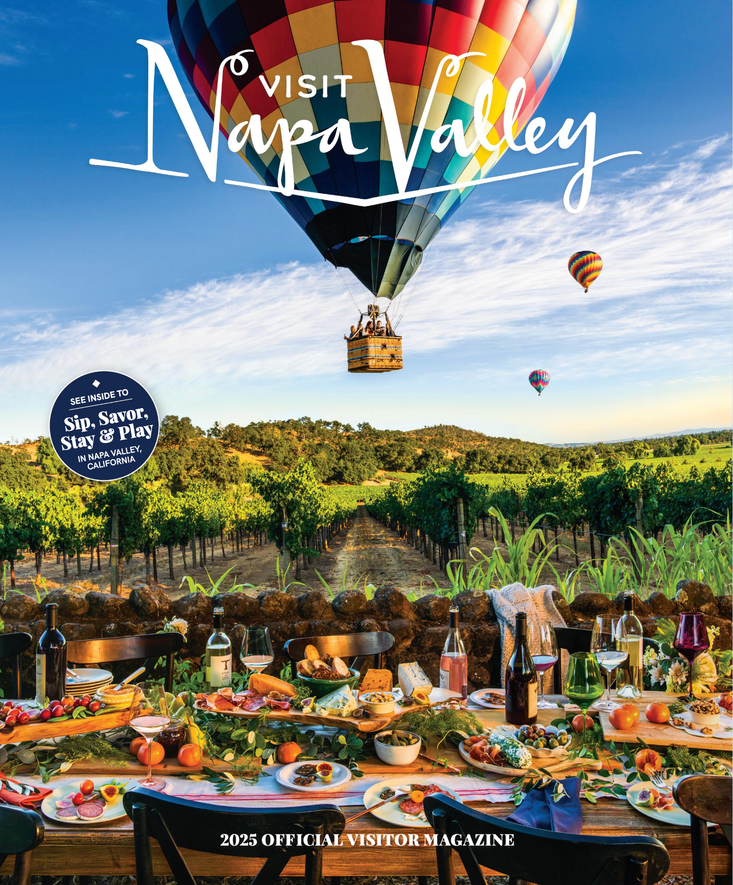 Hot air balloons float over Napa Valley vineyards while a gourmet food and wine spread is displayed on rustic table.
