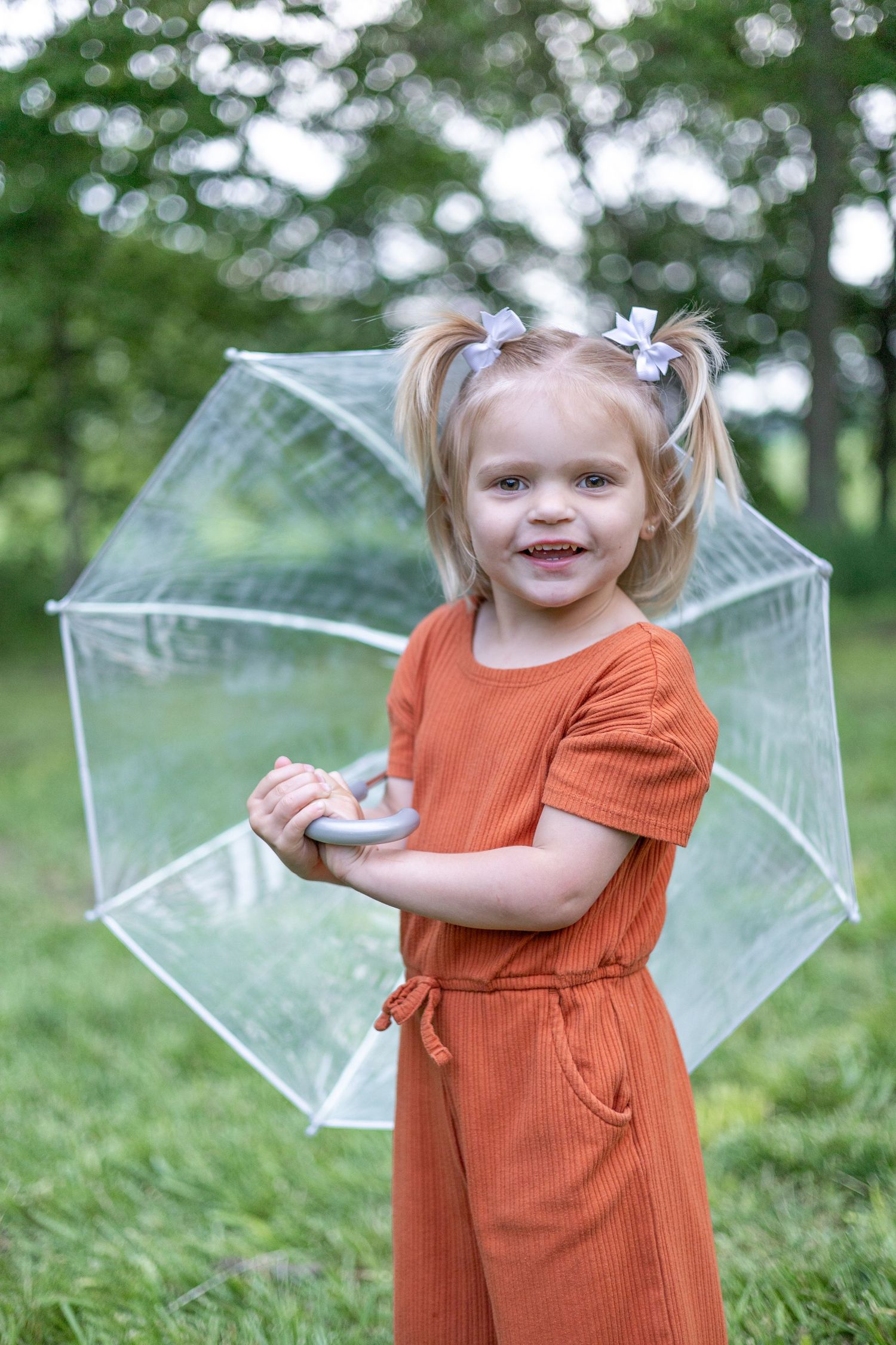 Springfield Illinois photographer captures a young girl smiling with an umbrella during a photo session in Central Illinois