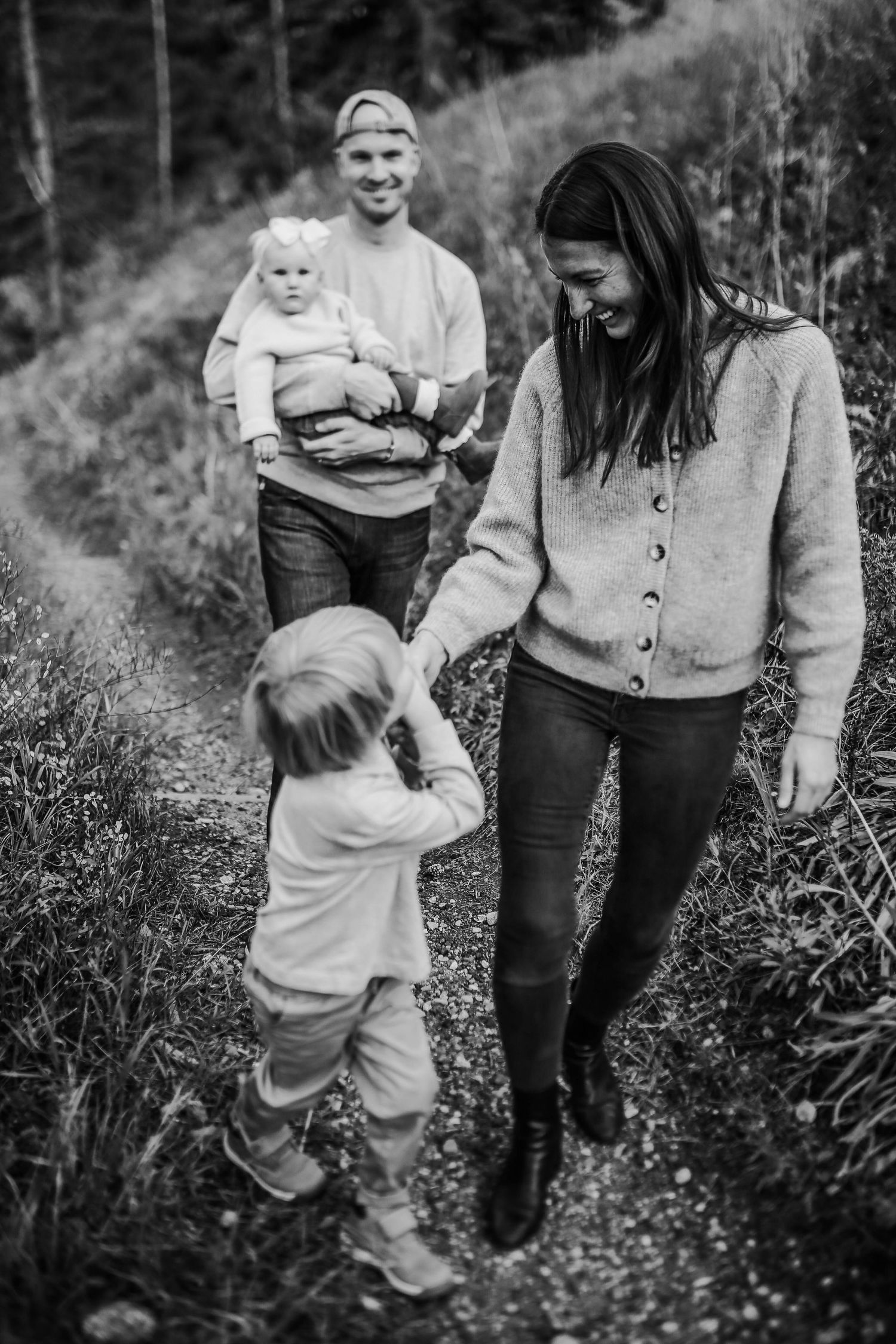 Black and white photo series of playful family moments in nature showing interaction between parent and child.