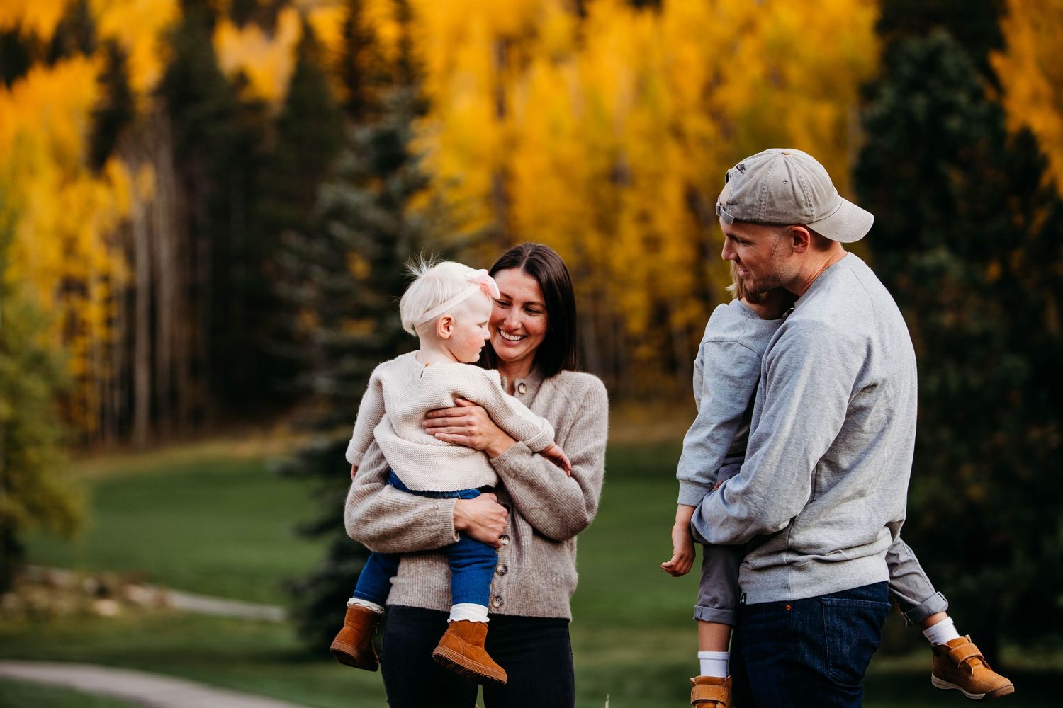 Family enjoying an autumn day outdoors with golden aspen trees creating a warm backdrop in nature.