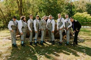 Groomsmen in gray suits lined up showing their matching blue and gray socks.