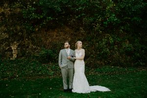 Bride and groom share a romantic moment in front of a decorated outdoor wedding arch.