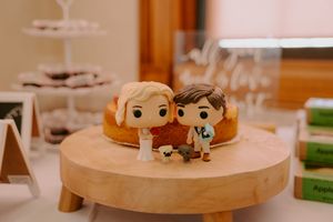 Decorative figurines displayed on wooden cake stands at wedding reception.
