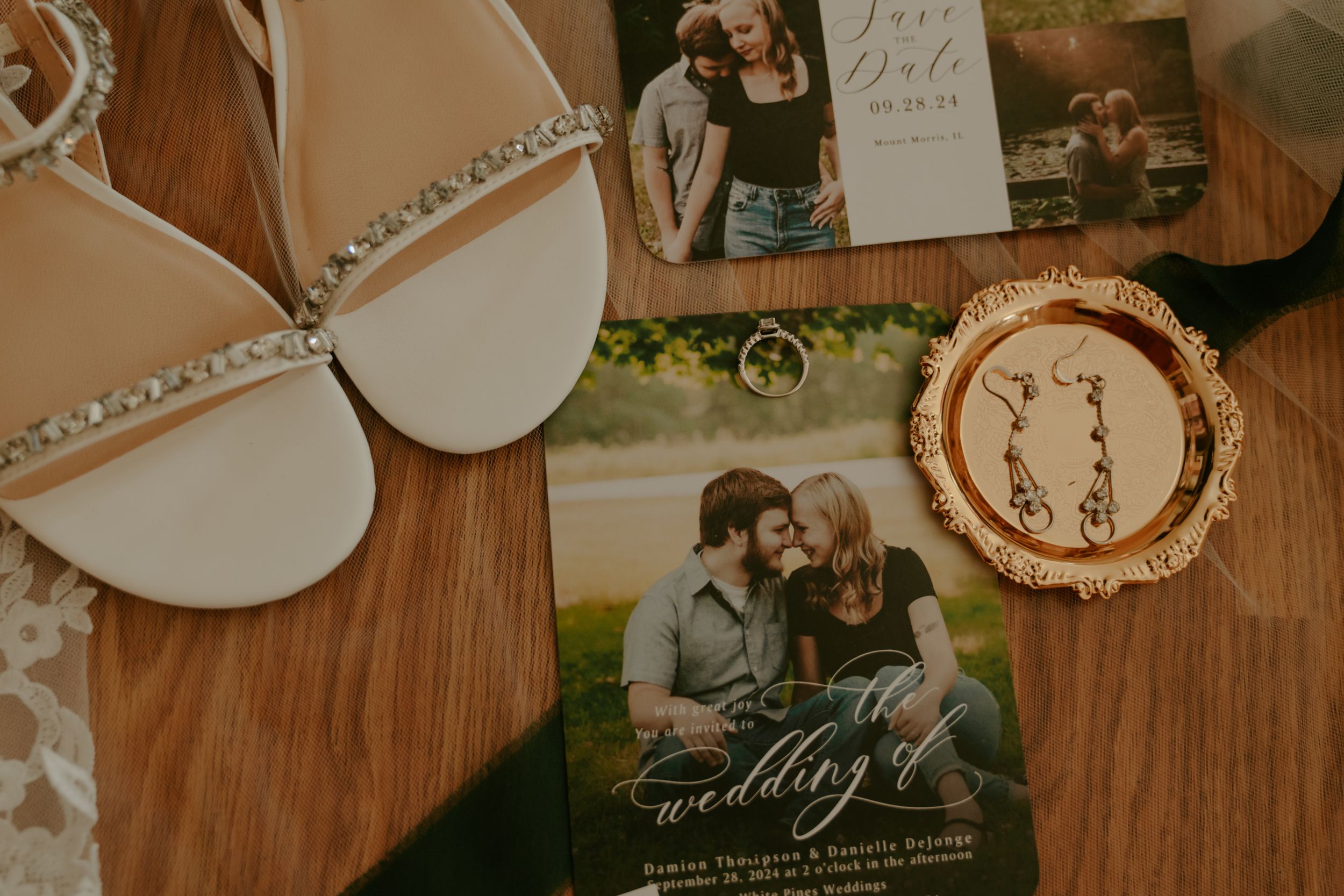 Wedding details and decorations arranged on a rustic wooden surface with vintage styling.
