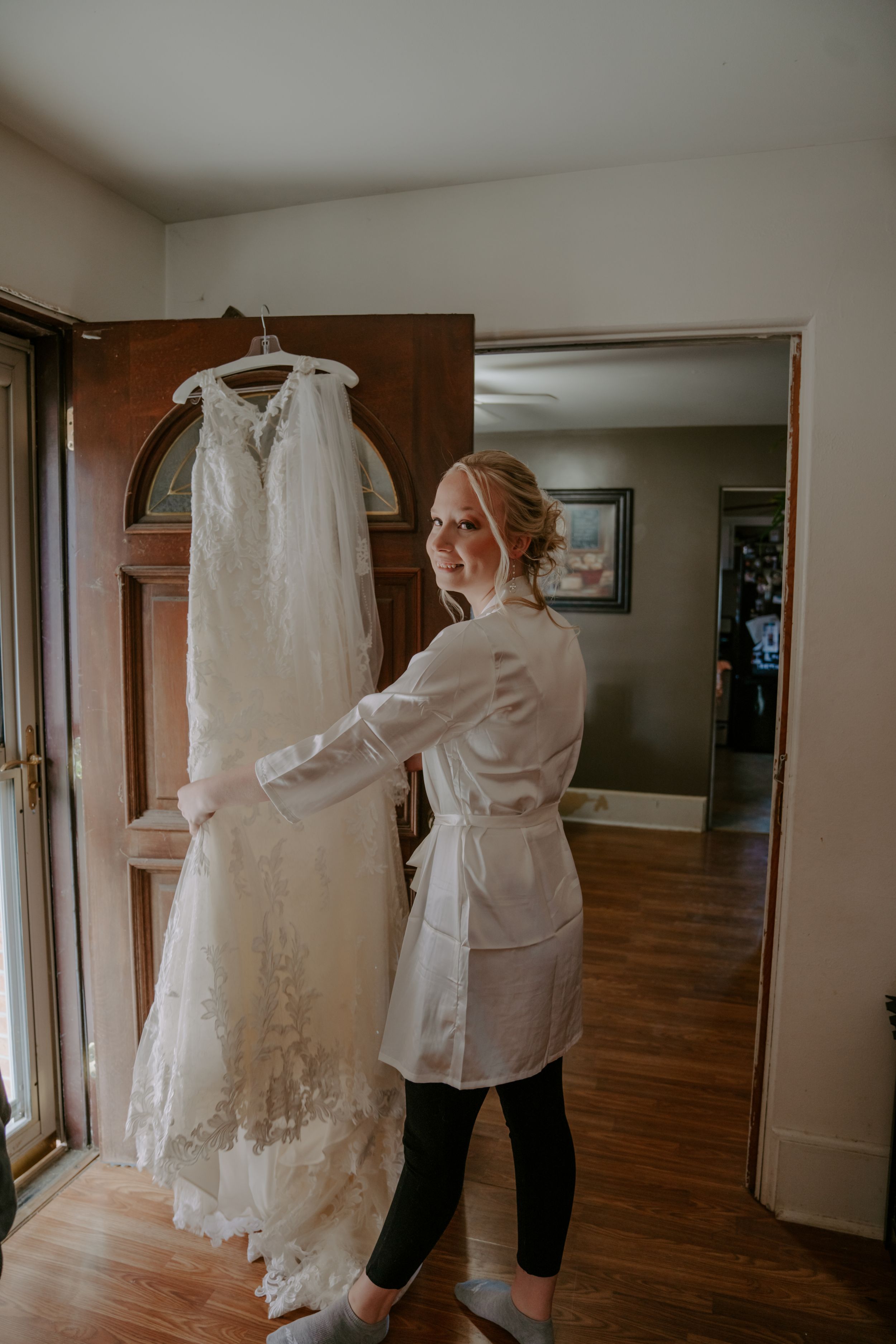 Wedding dress preparations in a spacious room with hardwood floors and natural lighting.