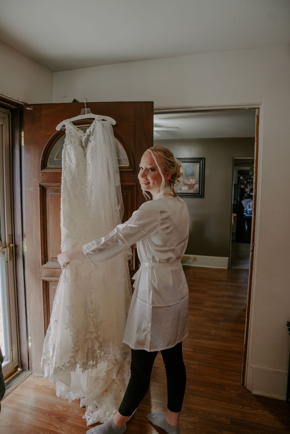 Wedding dress preparations in a spacious room with hardwood floors and natural lighting.