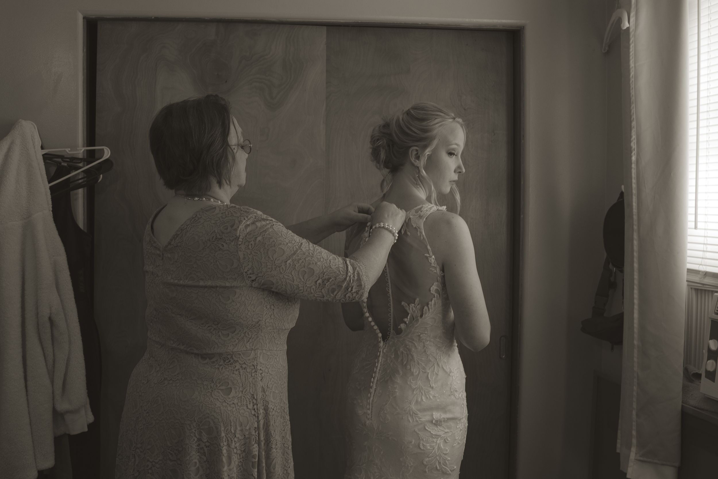Wedding dress fittings and preparations in a dimly lit interior space.
