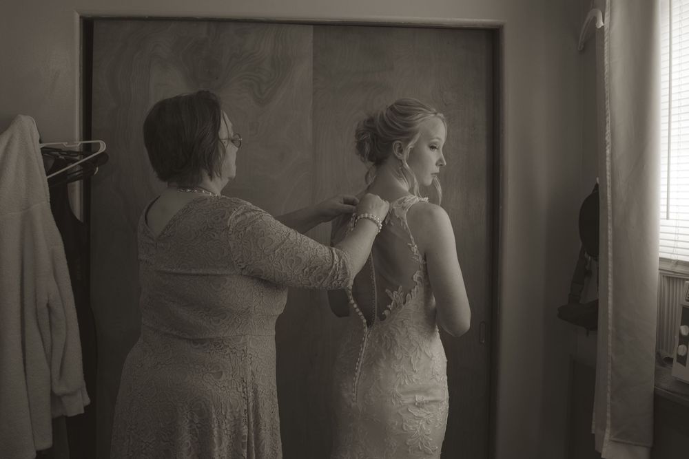 Wedding dress fittings and preparations in a dimly lit interior space.