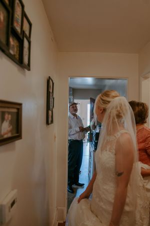 Wedding preparation moments captured in a hallway with natural lighting.